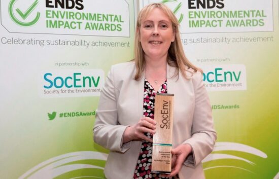 chartered environmental woman smiling whilst holding an SocEnv award